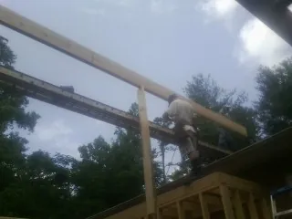 Carpenter setting a ridge beam over a new addition frame — Ice Dam Removal by Roofing Brothers in Sea Girt